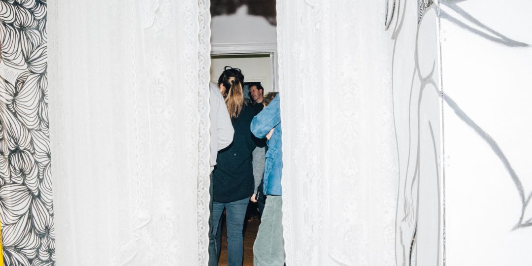 People visible behind the curtain at an event during Stockholm Design Week